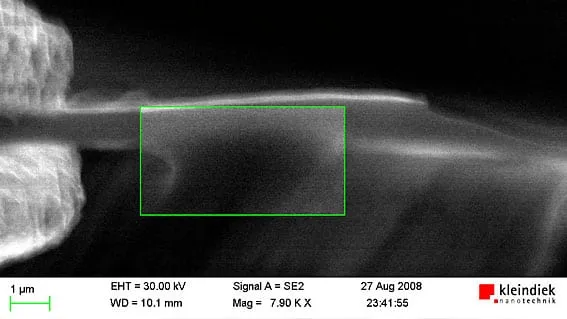 SEM close-up of a cured SemGlu fillet at a fibre junction, with a green measurement box and a 1 micrometre scale bar.