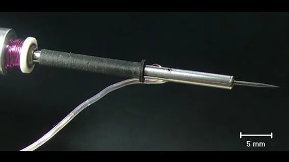 Close-up of the MSU heated tip and coiled heater wire against a black background, with a 5 mm scale bar.