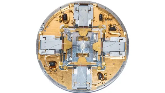 The PS4 Prober Shuttle hardware — a circular stage carrying four ultra-flat MM4 manipulators with copper and gold detail.